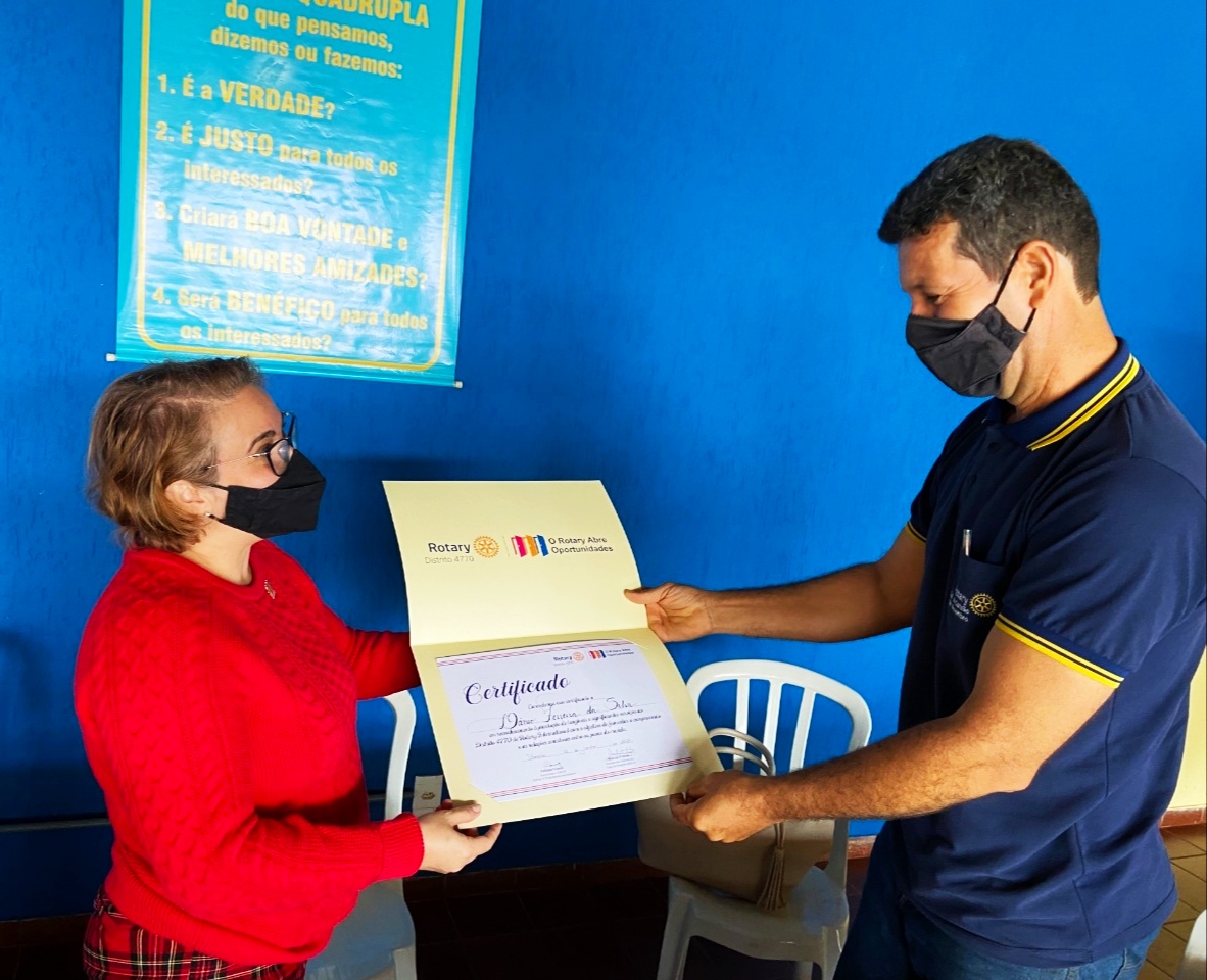A governadora do Distrito RI 4770 entregando ao presidente do Rotary Club Catalão 1° de Novembro Dânio Ferreira o certificado de cumprimento de metas do Ano Rotário 2020/21