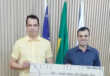 Hernany Ferreira Gondim repassando cheque simbólico de R$ 194.500,00 ao prefeito de Cumari João Rios