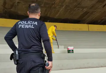 Reeducandos trabalham na pintura da arquibancada do Serra Dourada, em Goiânia, sob vigilância policial